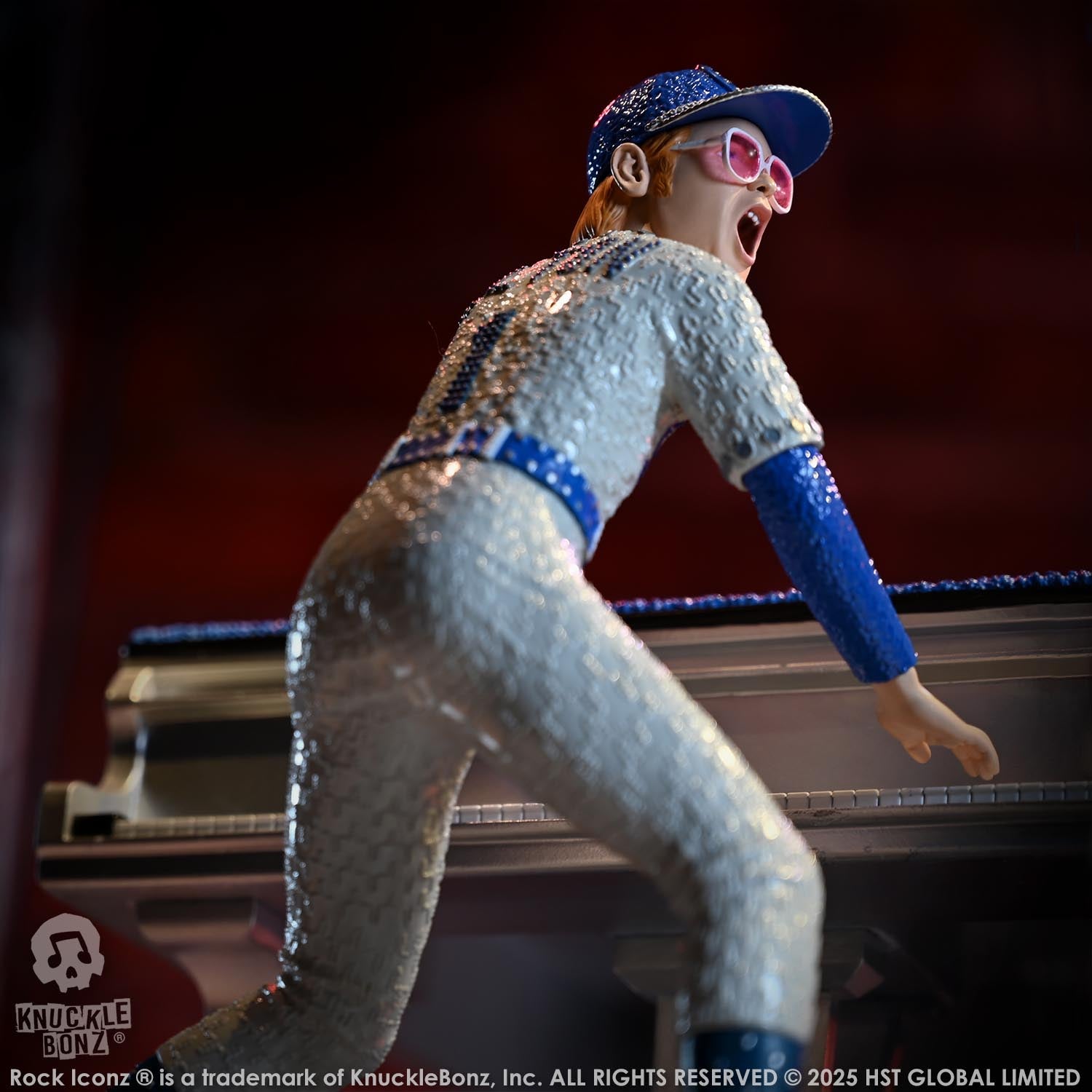 Statue of Elton John with a grand piano in a baseball uniform with a red background